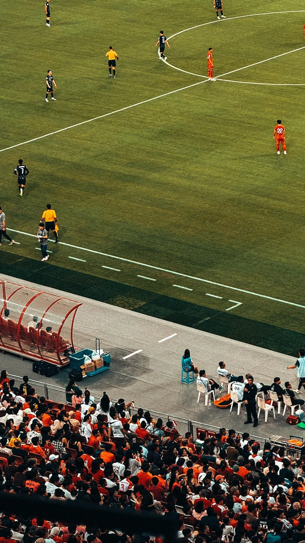 Players and a full crowd across a professional football stadium